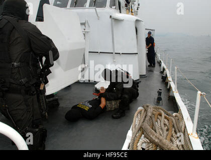 110614-N-NJ145-228 KEMAMAN, Malaysia (June 14, 2011) Malaysian Maritime Enforcement Agency Star Team members apprehend a simulated suspect while U.S. Coast Guard Maritime Safety and Security Team personnel observe a tactical boarding training exercise aboard a Malaysian offshore patrol vessel during Cooperation Afloat Readiness and Training (CARAT) Malaysia 2011. CARAT is a series of bilateral exercises held annually in Southeast Asia to strengthen relationships and enhance force readiness. (U.S. Navy photo by Mass Communication Specialist 1st Class Robert Clowney/Released) CARAT Malaysia 2011 Stock Photo