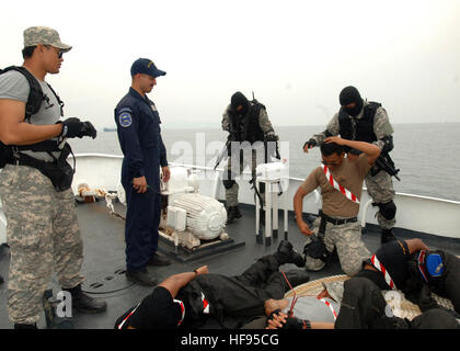 110614-N-NJ145-325 KEMAMAN, Malaysia (June 14, 2011) Malaysian Maritime Enforcement Agency Star Team apprehend simulated crewmembers while U.S. Coast Guard Maritime Safety and Security Team personnel observe a tactical boarding training exercise aboard a Malaysian  offshore patrol vessel during Cooperation Afloat Readiness and Training (CARAT) Malaysia 2011. CARAT is a series of bilateral exercises held annually in Southeast Asia to strengthen relationships and enhance force readiness. (U.S. Navy photo by Mass Communication Specialist 1st Class Robert Clowney/Released) CARAT Malaysia 2011 (110 Stock Photo