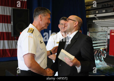 On board USS Wasp (LHD 1)  Vice Adm. Dean McFadden, Canada's Chief of Maritime Staff, presents a book regarding the History of Canada's Navy to the U.S. Ambassador to Canada, David Jacobson during a reception commemorating  Canada's Navy Centennial and International Fleet Review on board USS Wasp (LHD1) in Halifax, Nova Scotia.  Wasp is currently participating in the CNC/IFR that began on June 25 and concludes July 2. Wasp Sailors and Marines including embarked Carrier Strike Group 2, Helicopter Sea Combat Squadron 22 and 2nd Marines are participating in various cultural and sporting events du Stock Photo