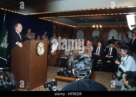 Secretary of Defense Richard Cheney responds to questions from the media while taking part in a press conference held by U.S. and Saudi Arabian officials during Operation Desert Storm.   Seated in the background are:  Gen. Colin Powell, chairman, Joint Chiefs of Staff; Gen. Norman Schwarzkopf, commander-in-chief, U.S. Central Command; and Paul D. Wolfowitz, under secretary of Defense for policy. Cheney Gulf War news conference Stock Photo