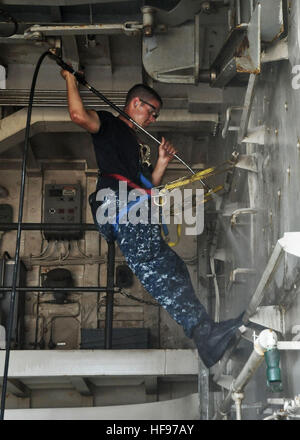 U.S. Navy Seaman Jeremy McGraw uses a pressure washer to clean a bulkhead aboard the amphibious transport dock USS New York (LPD 21) under way in the Gulf of Aden Sept. 17, 2012. New York and the embarked U.S. Marines assigned to the 24th Marine Expeditionary Unit are supporting maritime security operations and theater security cooperation efforts in the U.S. 5th Fleet?s area of responsibility while deployed with the Iwo Jima Amphibious Ready Group. (U.S. Navy photo by Mass Communication Specialist 2nd Class Zane Ecklund/Released) Cleaning a bulkhead 120917-N-NN926-026 Stock Photo