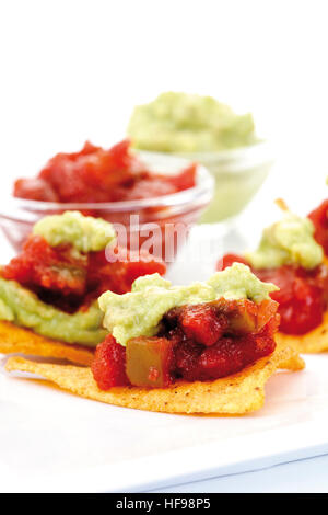 Tortilla chips with spicy tomato salsa and guacamole (avocado dip) Stock Photo