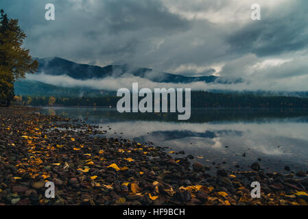 Autumn leaves on the shores of a reflective lake. Stock Photo