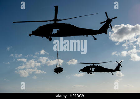 A Sikorsky MH-60S Sea Hawk helicopter transfers munitions from the USN Nimitz-class aircraft carrier USS Dwight D. Eisenhower to the Supply-class fast combat support ship USNS Arctic December 14, 2016 in the Mediterranean Sea. Stock Photo