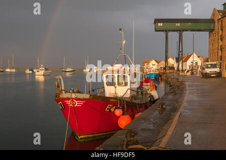 A rainbow forms over Wells-next-the-Sea during a summer evening storm. Stock Photo