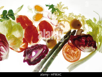 Vegetables and ham, lettuce, smoked ham, radicchio, hard boiled eggs, radish slices, endive salad, lemon slice, green asparagus Stock Photo