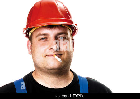 Construction worker wearing red hardhat smoking a cigarette Stock Photo