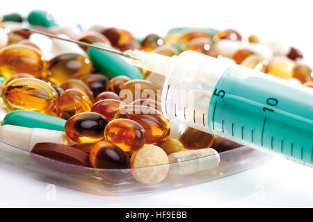 Pills formed in the shape of a heart, syringe, closeup Stock Photo