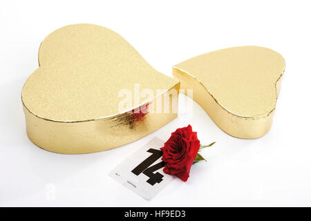 Golden heart-shaped gift boxes, red rose and calendar page marking February 14th, Valentine's Day Stock Photo