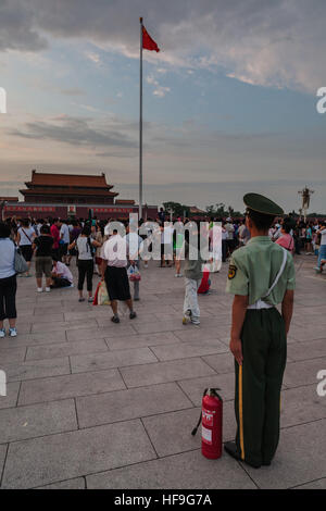 Soldier standing guard in Tiananmen Square in front of the Forbidden city in Beijing China with a fire-extinguisher close to him Stock Photo