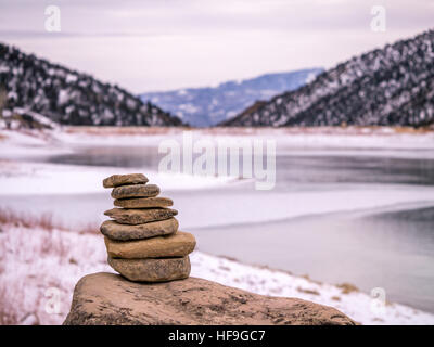 Rock cairn, frozen lake, winter in Colorado Stock Photo