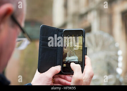 Close up of Man taking photo photographing ice sculpture with Iphone cell phone in winter York North Yorkshire England UK United Kingdom Great Britain Stock Photo