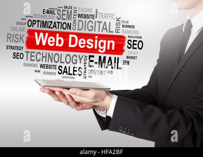 Web Design concept, young man holding a tablet computer Stock Photo
