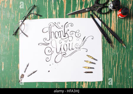 Thank you note calligraphy with writing equipment on the table Stock Photo