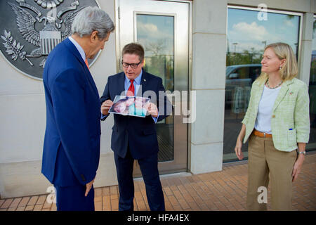 U.S. Embassy Deputy Chief of Mission Matt Roth, watched by U.S. Ambassador to Rwanda Erica Barks-Ruggles, shows U.S. Secretary of State John Kerry a photo of his wife and children back home in the United States before the Secretary greets staff members and their families from U.S. Embassy Kigali during a visit to the Rwandan capital on October 14, 2016, to attend a conference focused on amending the Montreal ozone layer protection protocol. Stock Photo