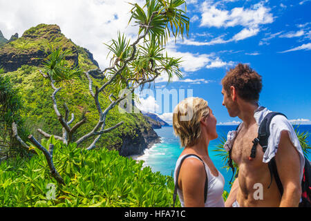 Couple on the Kalalau Trail on Kauai stop to admire view of the Na Pali Coast Stock Photo