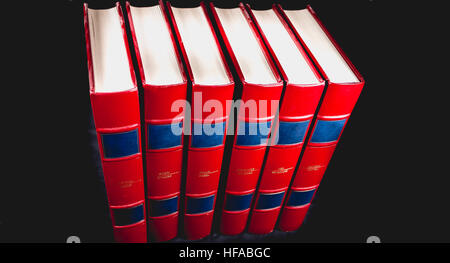 Old red encyclopedias bound leather on black background Stock Photo
