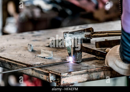HDR image of a technician using welder in factory's workshop Stock Photo