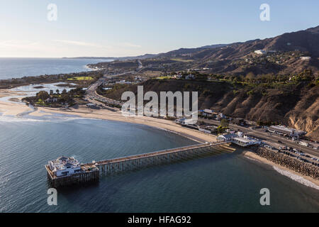 Aerial of historic Malibu Pier, Pacific ocean beaches and the Santa Monica Mountains in Southern California.