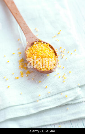 Raw organic Polenta Corn Meal (Grits) over white wooden background with copy space - healthy food ingredient Stock Photo