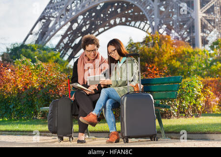 Travelers sitting on a bench near the Eiffel Tower Stock Photo
