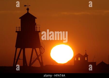 The sun rises over the Groyne lighthouse at South Shields on the mouth of the River Tyne.