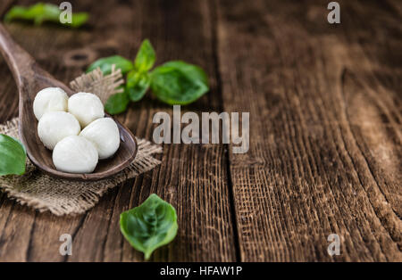 Small Mozzarella balls (on wooden background; selective focus) as close-up shot Stock Photo