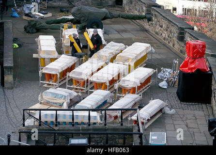 Pyro-technicians Shaun Gibson and Lynn Wiseman from Titanium Fireworks set up some of the 2.6 tonnes of fireworks along the ramparts of Edinburgh Castle ahead of the Hogmanay fireworks display for the New Year. Stock Photo