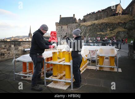 Pyro-technicians Shaun Gibson and Lynn Wiseman from Titanium Fireworks set up some of the 2.6 tonnes of fireworks along the ramparts of Edinburgh Castle ahead of the Hogmanay fireworks display for the New Year. Stock Photo