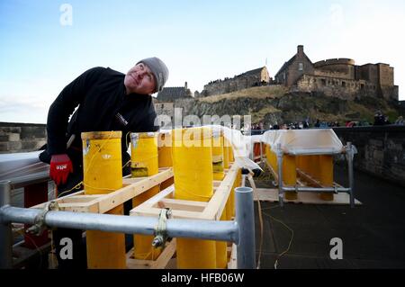 Pyro-technician Shaun Gibson from Titanium Fireworks sets up some of the 2.6 tonnes of fireworks along the ramparts of Edinburgh Castle ahead of the Hogmanay fireworks display for the New Year. Stock Photo