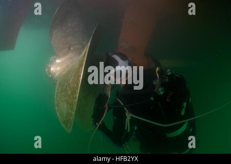 The U.S. Navy diver assigned to Commander, Task Group 56.1 inspected a propeller after removing a fouled line from a Coast Guard cutter, during operations including mine countermeasures, explosive ordnance disposal, salvage diving, and force protection in the 5th Fleet area of responsibility. Stock Photo