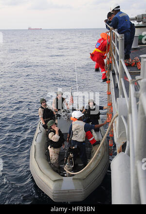 090211-N-1082Z-232 GULF OF ADEN (Feb. 11, 2009) Crew members from the Marshall Islands -flagged cargo ship, M/V Polaris, climb aboard the guided-missile cruiser USS Vella Gulf (CG 72) to identify suspected pirates apprehended by the Vella Gulf visit, board,  search and seizure (VBSS) team. Vella Gulf is the flagship for Combined Task Force 151, a multi-national task force conducting counterpiracy operations to detect and deter piracy in and around the Gulf of Aden, Arabian Gulf, Indian Ocean and Red Sea. It was established to create a maritime lawful order and develop security in the maritime  Stock Photo