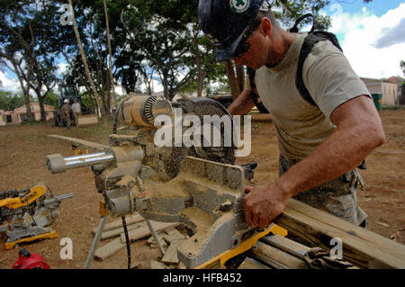 Air Force Staff Sgt. Scott Boucher, embarked aboard the amphibious assault ship USS Kearsarge, saws a board for a wall brace in a Southeast Asia hut to expand Presbitero Carlos Novel Primary School as part of the humanitarian/civic assistance mission Continuing Promis 2008. Kearsarge is supporting the Caribbean phase of CP, an equal-partnership mission between the United States, Canada, the Netherlands, France, Brazil, Nicaragua, Colombia, Dominican Republic, Trinidad and Tobago and Guyana. Construction for a school 122598 Stock Photo