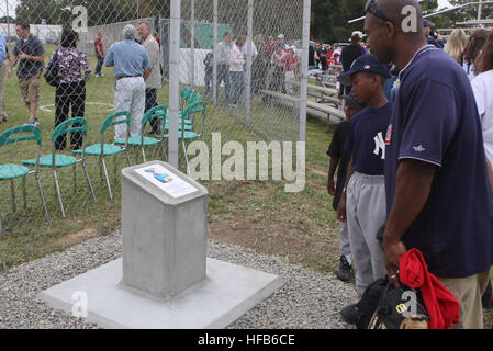 Service members and dependents read a plaque dedicating a baseball field at U.S. Naval Station Rota, Spain to Cmdr. Charles 'Keith' Springle. Springle, a former medical service officer, was one of five service members killed by an Army sergeant at a military counseling clinic at Camp Liberty, Iraq, in May 2009. (U.S. Navy photo by Jan Hammond) Dedication Plaque 278254 Stock Photo