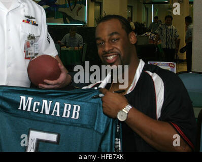 Philadelphia Eagles quarterback Donovan McNabb signed a football jersey belonging to Storekeeper 2nd Class Jason Winters of Fleet Industrial Supply Center, Pearl Harbor. McNabb visited the Silver Dolphin Bistro at Naval Station Pearl Harbor on Feb. 3 to meet with Sailors. (Photo by JO3 Corwin Colbert) Donovan McNabb Stock Photo