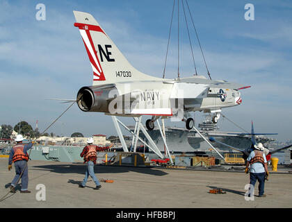 051227-N-3931M-028 San Diego (Dec. 27, 2005) - Crane riggers from the U.S. Navy Public Works Center (PWC) guide a F-8K Crusader aircraft onto a floating barge for delivery to USS Midway (CV 41) museum in downtown San Diego. For over 30 years, the F-8 Crusader served the U.S. Navy and Marine Corps as a front-line fighter and photo reconnaissance aircraft. U.S. Navy photo by PhotographerÕs Mate 1st Class Michael R. McCormick (RELEASED) F-8 Crusader US Navy Stock Photo