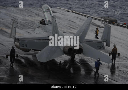 U.S. Navy boatswain's mates (Handling) transport an F/A-18F Super Hornet aircraft assigned to Strike Fighter Squadron (VFA) 154 across the flight deck of the aircraft carrier USS Nimitz (CVN 68) in the South China Sea Nov. 21, 2013. The Nimitz was deployed to the U.S. 7th Fleet area of responsibility supporting security and stability in the Indo-Asia-Pacific region. (U.S. Navy photo by Mass Communication Specialist Seaman Apprentice Kelly M. Agee/Released) F-A-18F Super Hornet 131121-N-AZ866-178 Stock Photo