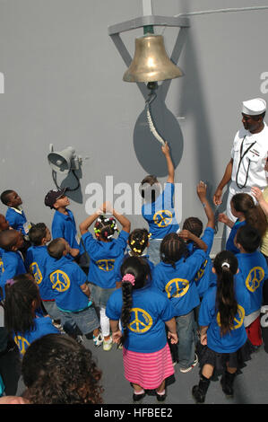 Petty Officer 2nd Class Damien Stone lets students from Public School 14 in Staten Island ring the ship's bell while touring the guided-missile cruiser USS Vella Gulf (CG 72) during Fleet Week New York City 2009. Approximately 3,000 Sailors, Marines and Coast Guardsman will participate in the 22nd commemoration of Fleet Week New York. This event will provide the citizens of New York City and the surrounding tri-state area an opportunity to meet service members and also see the latest capabilities of today's maritime services. Fleet Week New York City 2009 175074 Stock Photo