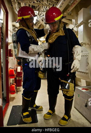 120825-N-XK513-104  GULF OF ADEN (Aug. 25, 2012) Damage Controlman 2nd Class David Dubis, left, helps Religious Programs Specialist 2nd Class Erin Hernandez, in dressing out in damage control gear during a general quarters drill aboard the amphibious transport dock ship USS New York (LPD 21). New York is part of the Iwo Jima Amphibious Ready Group and is deployed in support of maritime security operations and theater security cooperation efforts in the U.S. 5th Fleet area of responsibility. (U.S. Navy photo by Mass Communication Specialist 2nd Class Ian Carver/Released)  - Official U.S. Navy I Stock Photo