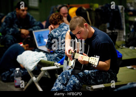 120828-N-PC102-288 GULFPORT, Miss. (Aug. 28, 2012) Damage Controlman Fireman Apprentice Jeffery Riser, assigned to the San Antonio-class amphibious transport dock ship Pre-Commissioning Unit Arlington (LPD 24), plays his guitar while living temporarily in an evacuation shelter at Naval Construction Battalion Center (NCBC), Gulfport. The base is making final preparations as Hurricane Isaac nears the Gulf Coast. The storm is expected to make landfall nearly 7 years after Hurricane Katrina. (U.S. Navy photo by Mass Communication Specialist 1st Class R. Jason Brunson/Released)  - Official U.S. Nav