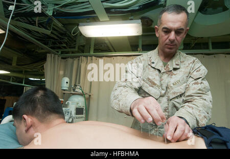 120216-N-PB383-282  ARABIAN GULF (Feb. 16, 2012) Cmdr. Yevsey Goldberg conducts an acupuncture procedure on a patient aboard the amphibious transport dock ship USS New Orleans (LPD 18). New Orleans and embarked Marines assigned to the 11th Marine Expeditionary Unit are deployed as part of the Makin Island Amphibious Ready Group, supporting maritime security operations and theater security cooperation efforts in the U.S. 5th Fleet area of responsibility. (U.S. Navy photo by Mass Communication Specialist 2nd Class Dominique Pineiro/Released)  - Official U.S. Navy Imagery - Cmdr. Yevsey Goldberg  Stock Photo