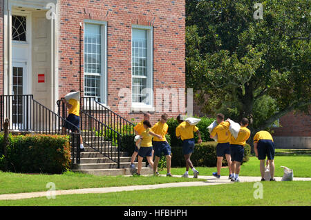 PENSACOLA, Fla. (Aug. 26, 2012) Students at Naval Aviation Schools Command at Naval Air Station Pensacola carry sandbags in preparation for Tropical Storm Isaac. The storm is expected to make landfall along the Gulf Coast late Tuesday evening. The last major storm to affect Northwest Florida was Hurricane Dennis, a category three hurricane, which made landfall near Pensacola July 10, 2005. (U.S. Navy Photo by Noel Nichols/Released) 120826-N-XX082-600 Join the conversation http://www.facebook.com/USNavy http://www.twitter.com/USNavy http://navylive.dodlive.mil  - Official U.S. Navy Imagery - Co Stock Photo