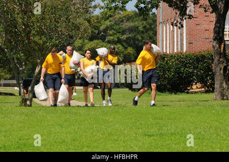 PENSACOLA, Fla. (Aug. 26, 2012) Students at Naval Aviation Schools Command at Naval Air Station Pensacola carry sandbags in preparation for Tropical Storm Isaac. The storm is expected to make landfall along the Gulf Coast late Tuesday evening. The last major storm to affect Northwest Florida was Hurricane Dennis, a category three hurricane, which made landfall near Pensacola July 10, 2005. (U.S. Navy Photo by Gary Nichols/Released) 120826-N-GS507-209 Join the conversation http://www.facebook.com/USNavy http://www.twitter.com/USNavy http://navylive.dodlive.mil  - Official U.S. Navy Imagery - Co Stock Photo