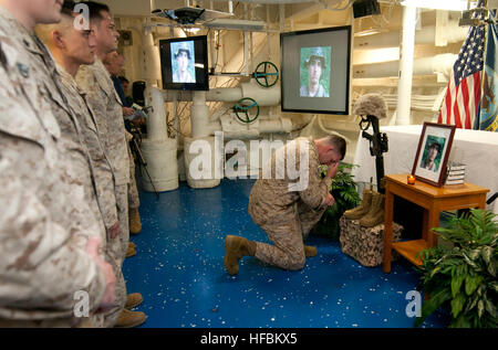 120219-N-PB383-072 ARABIAN GULF (Feb. 19, 2012) Lt. Jonathan Gower, a battle surgeon assigned to the 11th Marine Expeditionary Unit (11th MEU), pays his respects to Hospital Corpsman 3rd Class Kyler Estrada during a memorial ceremony in the chapel of the amphibious transport dock ship USS New Orleans (LPD 18). Estrada, who was assigned to the 11th MEU, died while conducting night live fire and maneuver training in Djibouti, Africa. New Orleans and embarked Marines assigned to the 11th MEU are deployed as part of the Makin Island Amphibious Ready Group, supporting maritime security operations a Stock Photo