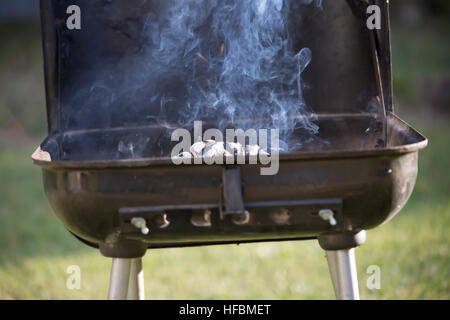 Charcoal smoking in open grill Stock Photo