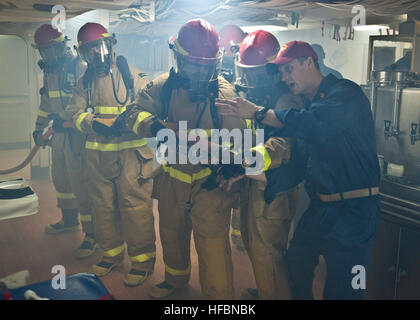 ARABIAN SEA (Oct. 11, 2012) Chief Hull Maintenance Technician Joshua Boleti, right, assigned to the amphibious transport dock ship USS New York (LPD 21), instructs Sailors during a simulated fire on the mess decks. New York is part of the Iwo Jima Amphibious Ready Group with the embarked 24th Marine Expeditionary Unit (24th MEU) and is deployed in support of maritime security operations and theater security cooperation efforts in the U.S. 5th Fleet area of responsibility. The U.S. Navy is reliable, flexible, and ready to respond worldwide on, above, and below the sea. Join the conversation on  Stock Photo