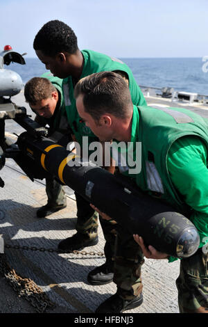 U.S. FIFTH FLEET AREA OF RESPONSIBILITY (Oct. 21, 2012) Aviation Electrician’s Mate 2nd Class Anthony Boccanelli, left, Aviation Electrician’s Mate Airman Jakarr Greenidge and Aviation Structural Mechanic (Hydraulics and Structures) 3rd Class Thomas Fiedler remove an AGM-114N Hellfire missile from an SH-60B Sea Hawk helicopter from the Proud Warriors of Helicopter Anti-submarine Squadron Light (HSL) 42, Det. 7, on the flight deck of the guided-missile destroyer USS Jason Dunham (DDG 109). Jason Dunham is deployed to the U.S. 5th Fleet area of responsibility conducting maritime security operati Stock Photo