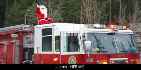 161218-N-UQ990-026 SILVERDALE, Wash. (Dec. 18, 2016) – Santa Claus gets a courtesy ride to Naval Base Kitsap (NBK) – Bangor family housing on a Navy Region Northwest (NRNW) Fire and Emergency Services truck. Santa and his helpers delivered candy to NBK residents at Bangor and Jackson Park. (U.S. Navy photo by Petty Officer 2nd Class Cierra Staples/Released) 161218-N-UQ990-026 161218-N-UQ990-026 Stock Photo