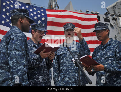 GULF OF ADEN (Sept. 11, 2012) Electrician's Mate 2nd Class Archie Mew, left, Engineman 2nd Class Matthew Smith, Cryptologic Technician Technical 3rd Class Ryan Leclair, and Seaman Cyrus Roson, sing 'The Star-Spangled Banner' during a remembrance ceremony aboard the amphibious transport dock ship USS New York (LPD 21) to commemorate the 11th anniversary of the Sept. 11, 2001 terrorist attacks. New York is part of the Iwo Jima Amphibious Ready Group with the embarked 24th Marine Expeditionary Unit (24 MEU). New York is built with 7.5 tons of steel salvaged from the World Trade Center. New york i Stock Photo