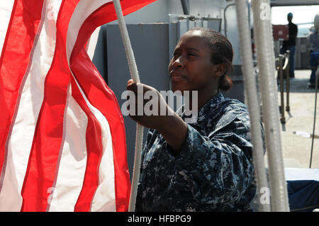 PORTSMOUTH, Va. (Aug. 13, 2012) Quartermaster 1st Class Candice Stone lowers the national ensign aboard the aircraft carrier USS George H.W. Bush (CVN 77). George H.W. Bush is undergoing a planned incremental availability at Norfolk Naval Shipyard to refurbish shipboard systems and conduct maintenance. (U.S. Navy photo by Mass Communication Specialist 2nd Class Timothy Walter/Released) 120813-N-FU443-447 Join the conversation www.facebook.com/USNavy www.twitter.com/USNavy navylive.dodlive.mil  - Official U.S. Navy Imagery - Sailor lowers the American flag. Stock Photo